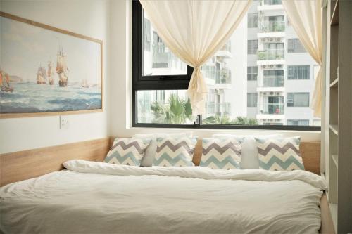 a bedroom with a bed with a large window at Nera Stay Huế - Luxury Apartment in Hue