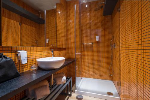 a bathroom with a sink and a shower at HF Ala Sul in Porto