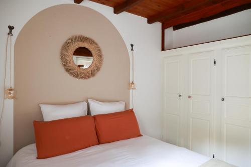 a bedroom with a bed with a mirror on the wall at Les Terrasses du Maquis in Nonza