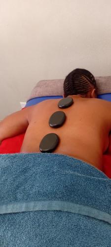 a man laying on a bed with pills on his back at Epic touch B&B in Sandton