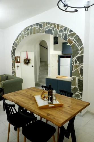 a dining room with a table and a stone archway at Arco In Pietra in Apolakkiá