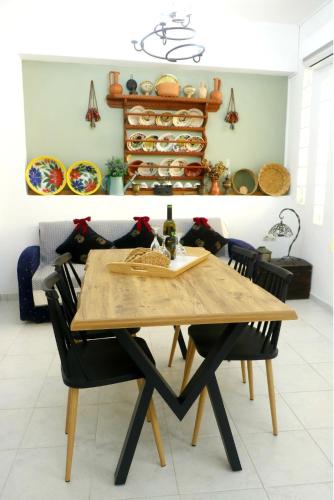 a dining room with a wooden table and chairs at Arco In Pietra in Apolakkiá