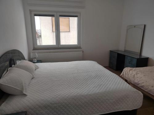 a bedroom with a large bed and a window at Apartman Lara in Kupres