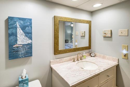 a bathroom with a sink and a mirror at Golfer's Getaway! Modern Diamondhead Condo in Diamondhead