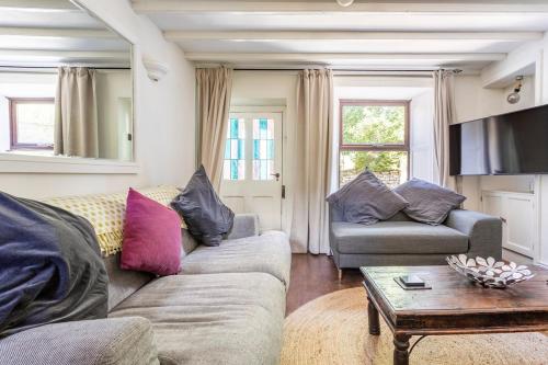 a living room with two couches and a coffee table at Rose Cottage. Family home on the river in Hawes