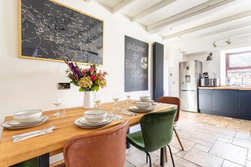a dining room with a wooden table and chairs at Rose Cottage. Family home on the river in Hawes
