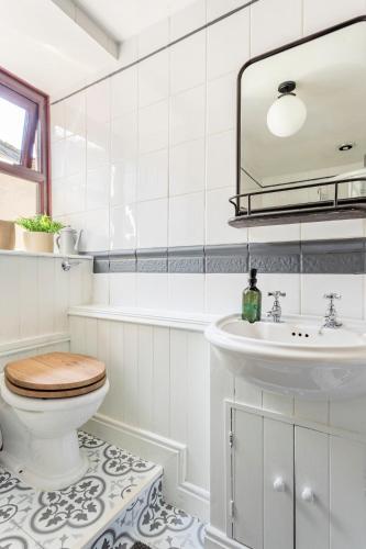 a bathroom with a toilet and a sink at Rose Cottage. Family home on the river in Hawes