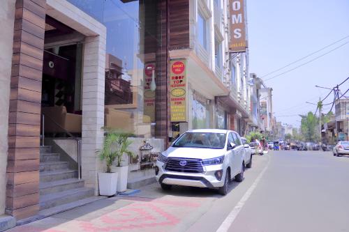 a white car parked on the side of a street at Hotel Landmark Near Golden Temple in Amritsar
