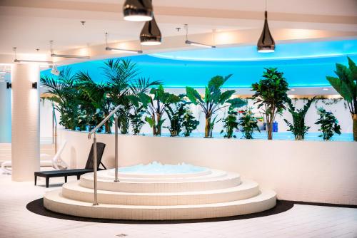 a lobby with a large exhibit with palm trees on the wall at HANZA Pionier 2 pokoje i balkon SPA & Pool Parking by stayly in Szczecin