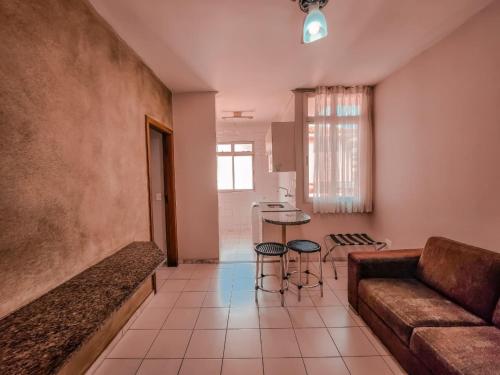 a living room with a couch and a table at Pampulha Flat in Belo Horizonte