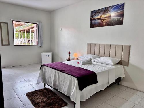 a bedroom with a large bed and a window at POUSADA ESTRELA DA MANHÃ in Barreirinhas