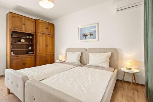 a bedroom with a large bed and wooden cabinets at Gortanova Bay Maisonette in Pula