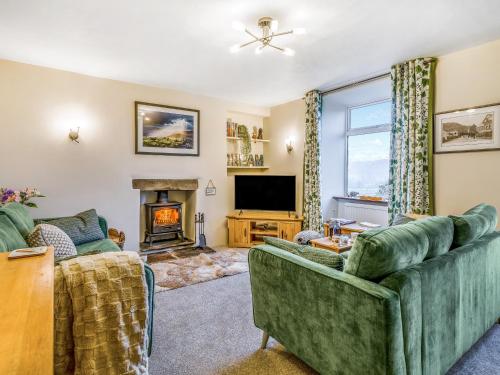 a living room with two couches and a fireplace at Carrie's Gate in Coniston