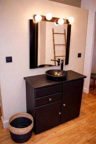 a bathroom with a sink and a mirror at Le Pré du Dimanche in Maringues