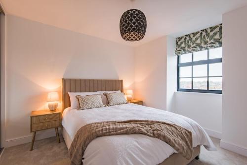 a bedroom with a bed and two lamps and a window at iDeal Apartment by Keepers Cottages in Deal