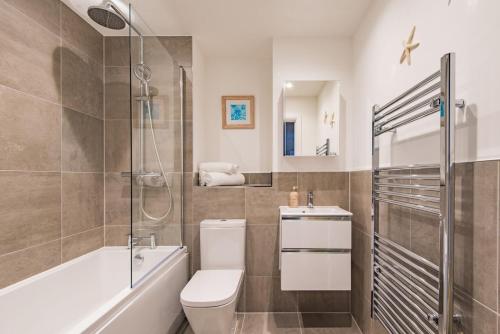 a bathroom with a toilet and a shower and a sink at iDeal Apartment by Keepers Cottages in Deal