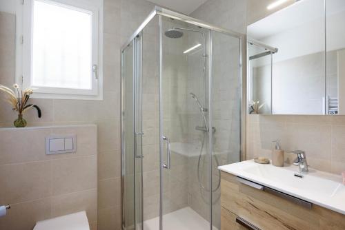 a bathroom with a glass shower and a sink at Villa Sole Flats in Saint Paul de Vence