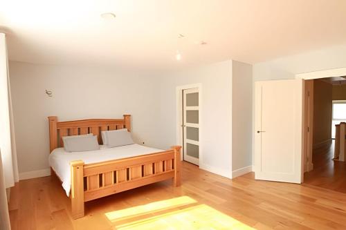 a bedroom with a wooden bed in a room at The Old Post Office Holiday Home, Dunmore in Galway