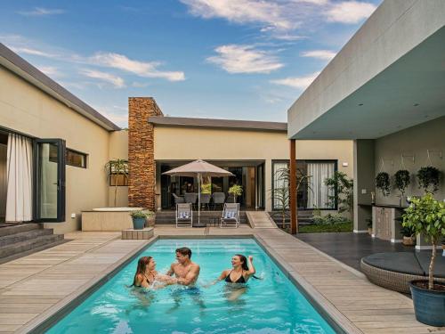 three people in a swimming pool in a house at Luxury Villa Rainbow, Eden Rock Estate, Pennington in Pennington