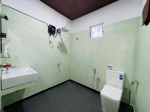 a bathroom with a toilet and a sink at Vihen Homestay in Dickwella
