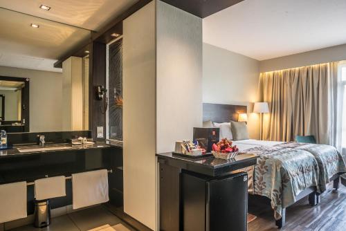 ein Hotelzimmer mit Bett und Waschbecken in der Unterkunft Eka Hotel Nairobi in Nairobi