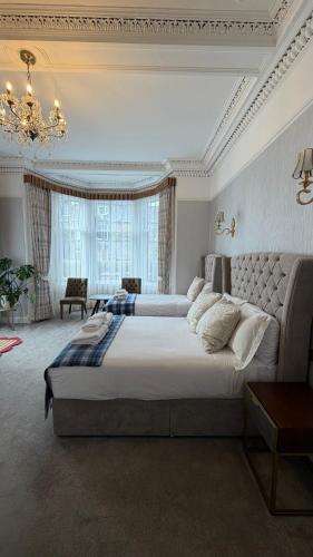 a large bedroom with a large bed and a chandelier at Kingston Guesthouse in Edinburgh