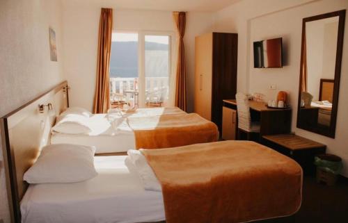a hotel room with two beds and a window at Hotel Villa Matić in Neum