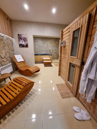 a room with a tub and two benches in a room at Horský Hotel Magura in Chvojnica