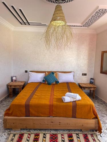 a bedroom with a large bed with two tables at Chez Manon & Said in Tamraght Ouzdar