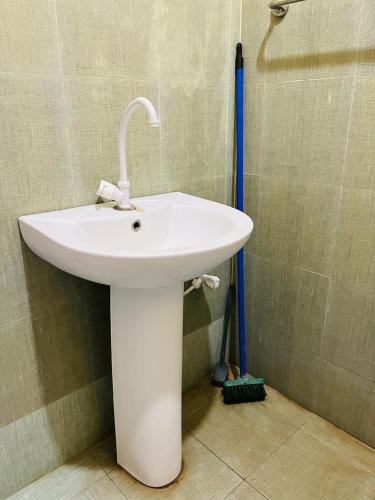 a white sink in a bathroom with a shower at Ranathunga Guest Kataragama in Kataragama
