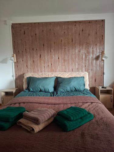 a large bed with two green pillows on it at Сонечко in Velyka Bihanʼ