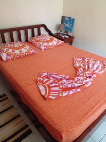 a bed with two pillows on top of it at Holidays in Martinique - Ravenala in Sainte-Anne