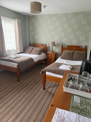 a bedroom with two beds and a table with a television at Wentworth arms in Malton