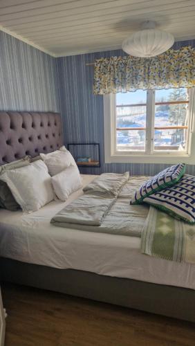a bedroom with a large bed with a window at Säbytorp in Kil
