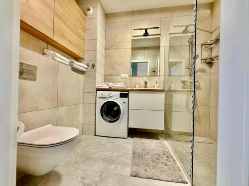 a bathroom with a toilet and a washing machine at Jarzebinowa Loft by JumpInHere in Nowy Dwór Mazowiecki