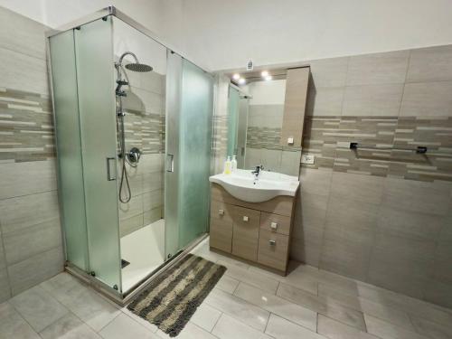 a bathroom with a glass shower and a sink at Casa Kennedy in Capaci