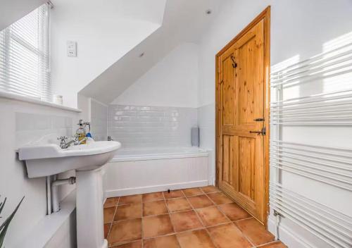 a bathroom with a sink and a bath tub at Charming Family Stables Conversion - Pass the Keys in Emsworth