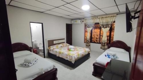 a room with two beds and a mirror at Hotel Gallineral in San Martín