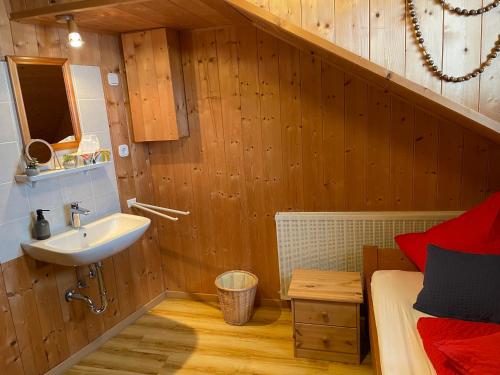a bathroom with a sink and a bed at Ferienhaus Talblick in Weiler-Simmerberg