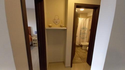 a hallway of a bathroom with a toilet and a mirror at Carcano Temporarios in Villa Carlos Paz
