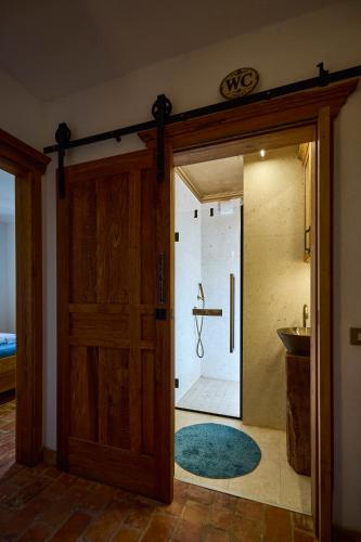a bathroom with a shower and a wooden door at Villa Stone Lace in Kolan