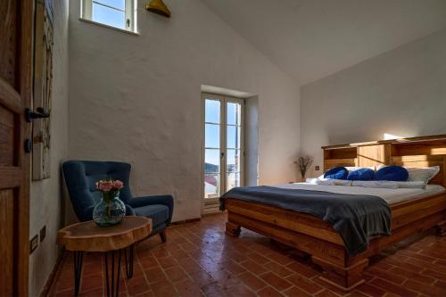 a bedroom with a bed and a chair and a window at Villa Stone Lace in Kolan