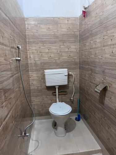 a bathroom with a white toilet in a room at Manjosila Homestay in Mirik