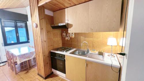 a kitchen with a sink and a stove at Baradello Apartment & Flat by ca-Sa Check in Le Bratte