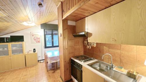 a kitchen with a sink and a stove at Baradello Apartment & Flat by ca-Sa Check in Le Bratte