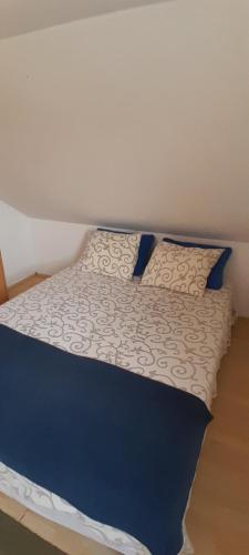 a bed with blue and white sheets and pillows at Airport Guesthouse Rooms and Apartmants in Beograd