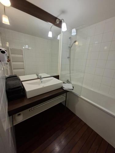 a bathroom with a white sink and a mirror at cottage poussin 12 picine lave linge in Chaveignes