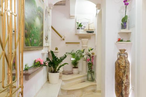 a hallway with stairs with potted plants and a vase at Mia Casa Dubrovnik in Dubrovnik