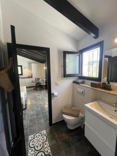 a bathroom with a toilet and a sink and a bedroom at Finca Bona Nit in Jávea