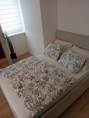 a large bed in a bedroom with a bedspread and pillows at Apartament 37 in Sosnowiec